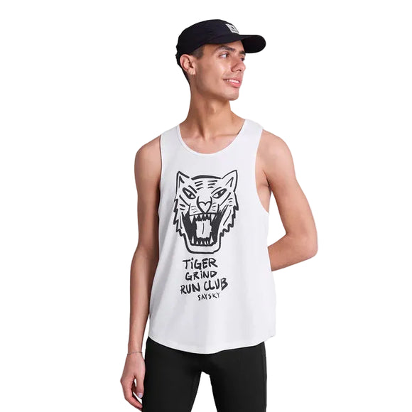 En person i sort kasket og hvid Saysky Tiger Combat Pro Singlet (Herre) med et tigerhoved og teksten "TIGER GRIND RUN CLUB SAYSKY" kigger til siden og smiler.