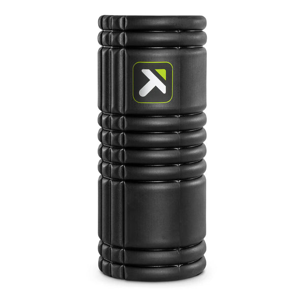 Trigger Point GRID 1.0 Foam Roller i sort står oprejst, ideel til muskelbehandling, og har et rektangulært logo med en hvid pil og grøn kant på siden.