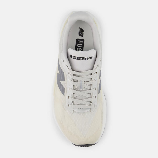 Topbillede af en New Balance Fuelcell Rebel V5 Dame løbesko i Linen/Grey Matter med hvide snørebånd og "FuelCell rebel"-branding på indersålen, designet til optimal energireturnering, vist på en almindelig hvid baggrund.