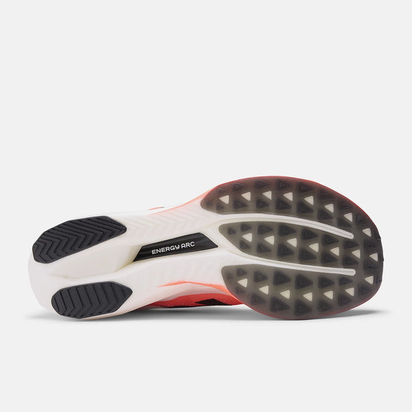 Billedet viser sålen på New Balance Fuelcell Supercomp Elite V5, Dame, Urgent Red løbesko med et struktureret mønster, sort gummi på hæl og tå og "ENERGY ARC" trykt på en central sort stribe.