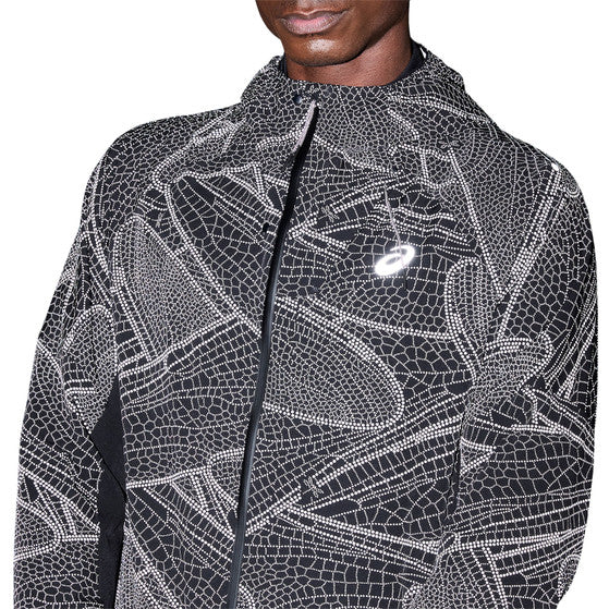 En mand er iført ASICS Limited Series Lite-Show Jacket, Herre, Performance Black, med geometrisk hvidt mønster, hætte, refleks-teknologi og logo på brystet. Billedet er beskåret under næsen med hovedet delvist ude af billedet.